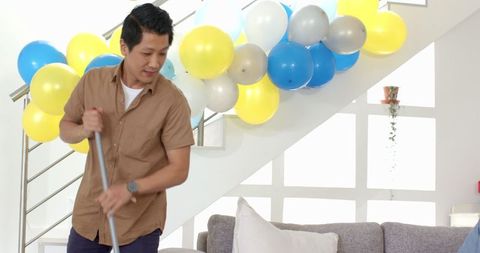Man cleaning living room after celebratory gathering