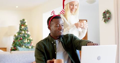 Diverse Couple Enjoying Cozy Holiday Time Together with Laptop