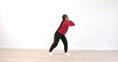 Vibrant Woman Dancing Energetically in Fashionable Red Jacket
