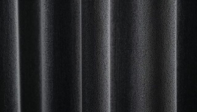Dark velvet curtain featuring deep vertical pleats and soft texture for elegant backdrops