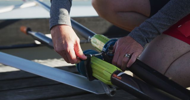 Person Fixing Rowing Equipment on Dock by Waterfront - Download Free Stock Images Pikwizard.com