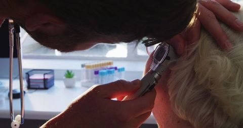 Doctor Examining Senior's Ear Amidst COVID-19 Concerns