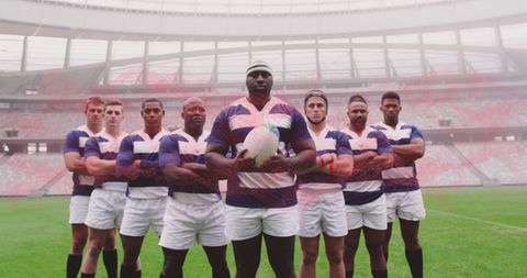 Confident rugby team standing united at futuristic stadium