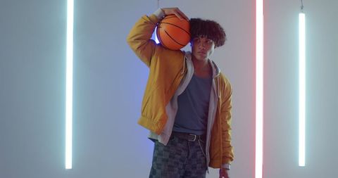 Young African American Man with Basketball in Neon Lit Studio