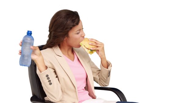 Businesswoman eating sandwich for lunch on white background