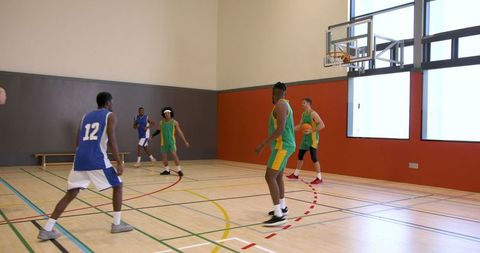 Diverse Basketball Players Competing in Indoor Gym