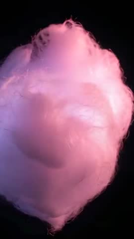 Vertical panning video showing glowing cotton candy tuft in pink and blue