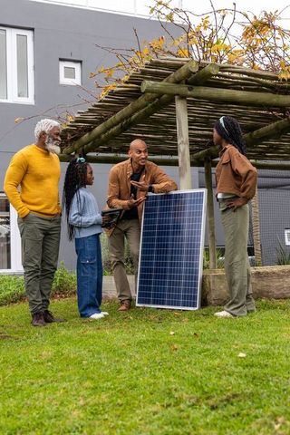 African american family exploring solar panel installation under backyard pergola, autumn
