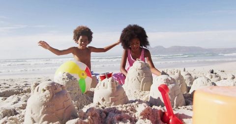 Children building sandcastles on beachside, vibrant and playful scene
