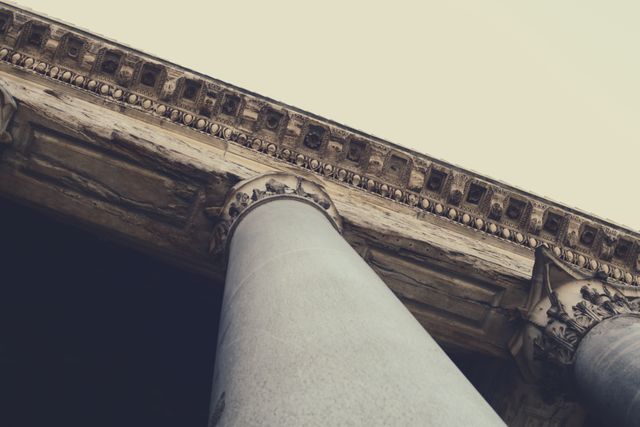 Close-up of the architectural details and columns of an ancient historic building highlighting classical design. Ideal for historical presentations, educational materials on architecture, or vintage-themed projects.