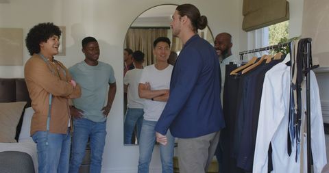 Friends choosing suits for wedding preparation at home