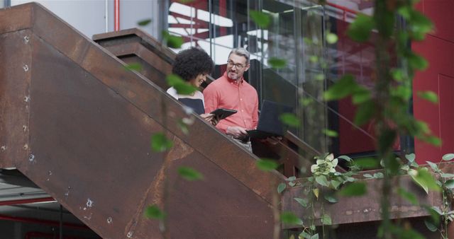 Diverse Colleagues Discussing Work on Staircase in Modern Office - Download Free Stock Images Pikwizard.com