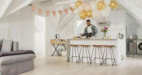 Man decorating modern kitchen for surprise celebration