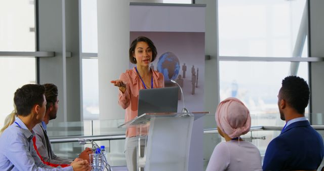 Front view of an Asian female speaker standing on the podium with her laptop and speaking to the public in a business seminar 4k