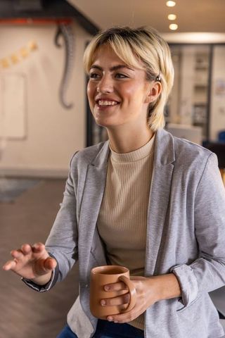 Professional Woman Engaging in Office Meeting with Coffee