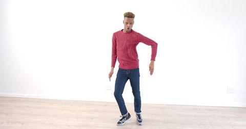 Young Man Dynamically Dancing on Wooden Floor