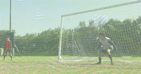 Youth soccer goalkeeper standing guard in striped jersey on sunny grass pitch