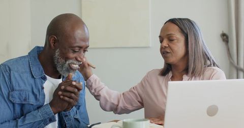 Senior Couple Sharing Tender Moment at Home with Laptop, Comfort and Companionship