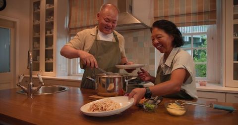 Senior Asian Couple Cooking Pasta Celebration at Home Kitchen