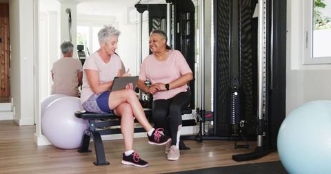 Older Women Using Tablet for Home Workout in Gym Room