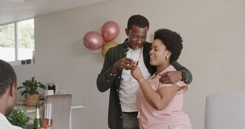 Happy Couple Embracing and Celebrating with Champagne at Home