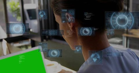Woman working on green-screen laptop in cafe with futuristic holographic ui overlay