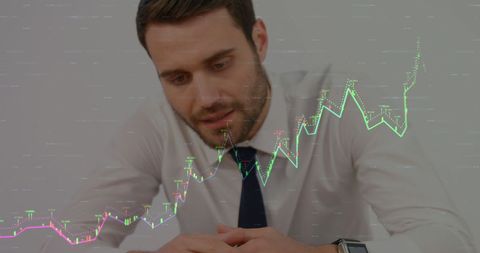 Caucasian businessman analyzing financial graphs in office