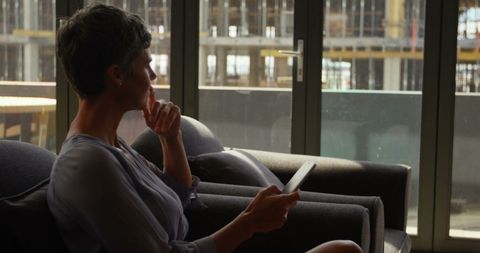 Businesswoman Contemplating Work in Sunlit Office