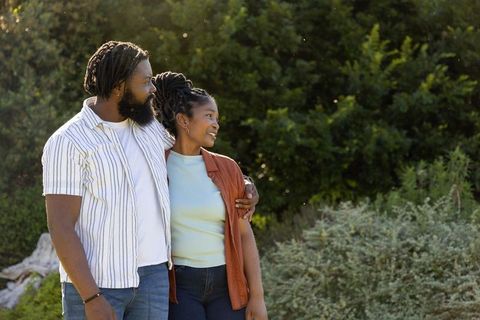 African american couple embracing in sunlit park during golden hour romance and relaxation