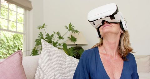 Middle-aged woman experiencing virtual reality at home
