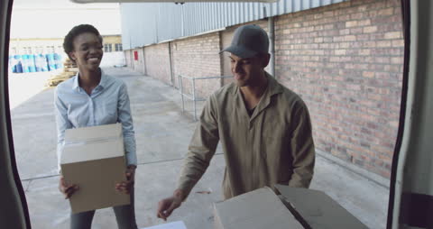 Young Warehouse Workers Loading Van with Boxes for Distribution