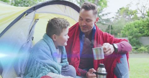 Father and Son Bonding Outdoors with Mugs and Blankets Moment