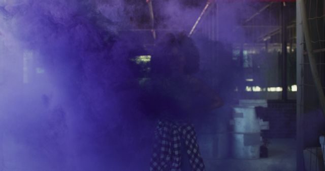Vibrant purple smoke fills indoor industrial space creating a mysterious and artistic atmosphere. This can be used to represent creativity, abstract concepts, or for marketing materials that require a bold and vibrant visual effect.