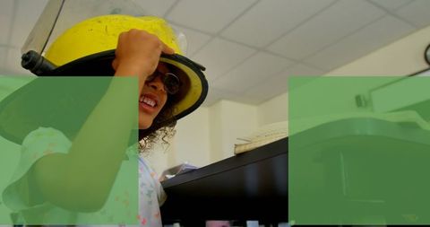 Young girl trying on firefighter hat indoors