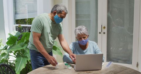 Senior Couple in Masks Reviewing Medical Information at Home - Download Free Stock Images Pikwizard.com