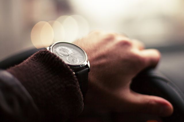 Close-Up of Hand Wearing Watch While Driving in City - Download Free Stock Images Pikwizard.com