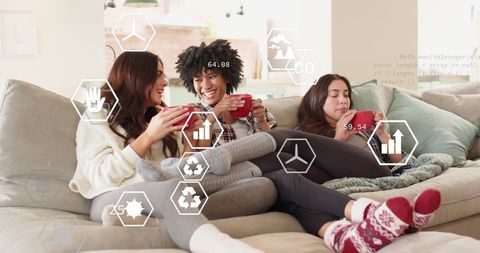 Three friends relaxing on sofa with red mugs and futuristic hexagon data overlays