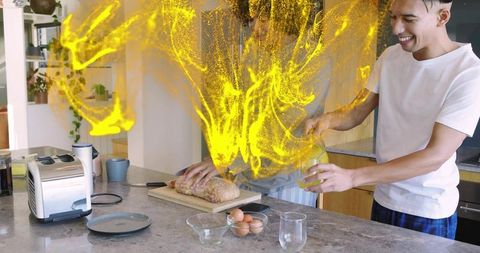 Friends preparing bread in home kitchen with yellow particle magic effect and casual teamwork