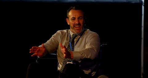 Disabled businessman speaking at seminar, engaged in discussion