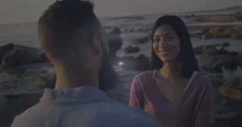 Romantic Couple on Rocky Beach at Sunset Enjoying Connection
