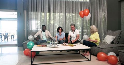 Diverse Group Tidying Up After Party in Modern Living Room