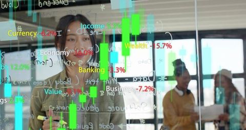 Asian businesswoman marking candlestick charts on glass board with team collaborating