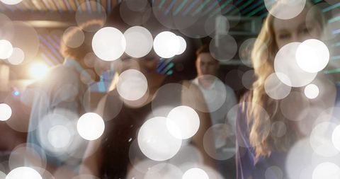 Young adults mingling in lounge with bokeh lights and warm nightlife glow