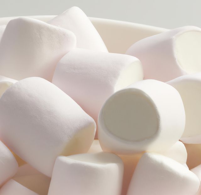 Close up of multiple white marshmallows lying on white background. Sweets, food and drink concept.