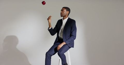 Confident Businessman Tossing Apple in Contemporary Style