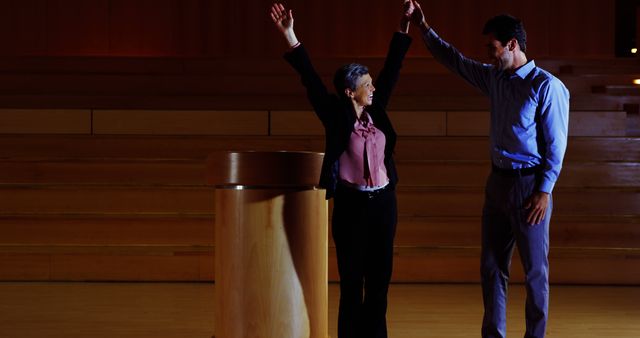 Celebrating Success on Stage with Raised Hands - Download Free Stock Images Pikwizard.com