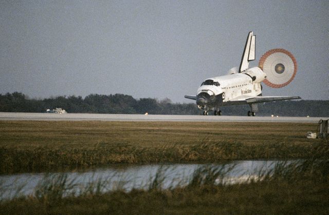STS063-S-015 (11 Feb. 1995) --- The Space Shuttle Discovery deploys its drag chute on Runway 15 at the Kennedy Space Center's (KSC) Shuttle Landing Facility as it wraps up an eight-day mission.  Touchdown occurred at 6:50:19 a.m. (EST), February 11, 1995.  Onboard the Space Shuttle Discovery were astronauts James D. Wetherbee, mission commander; Eileen M. Collins, pilot; Bernard A. Harris Jr., payload commander; mission specialists C. Michael Foale, Janice E. Voss, and cosmonaut Vladimir G. Titov.