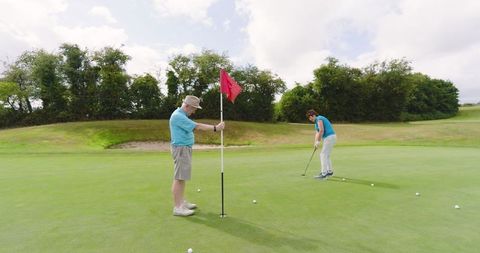 Senior couple enjoying golfing on sunny day