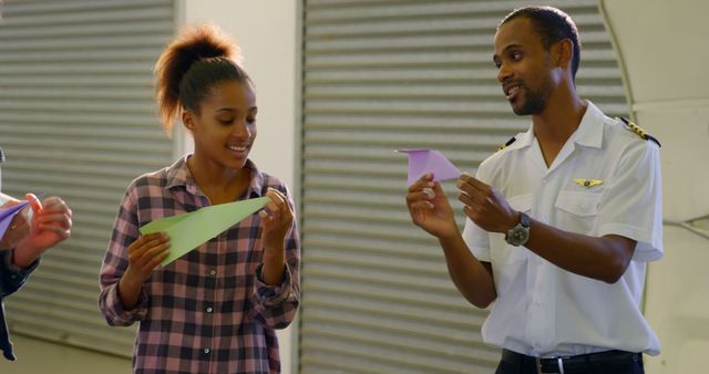 Pilot Teaching Young Girl How to Make Paper Airplanes in Hangar - Download Free Stock Images Pikwizard.com