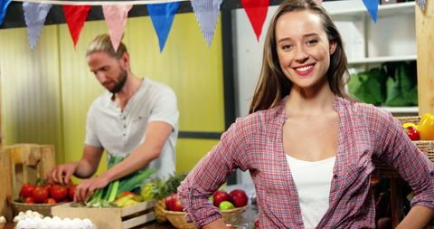 Smiling Woman at Vegetable Stand in Grocery Store